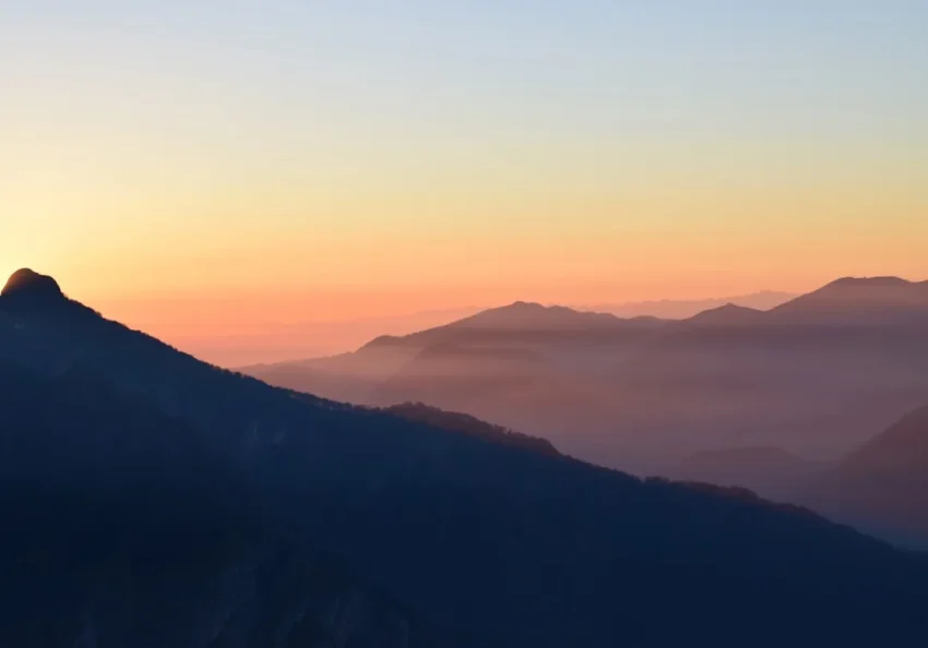 Climber ascending a mountain at sunrise symbolizing deliberate practice mastery journey