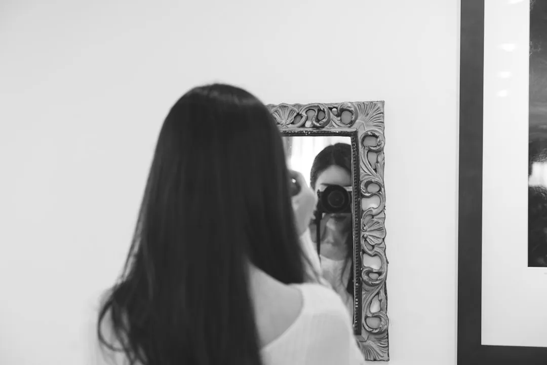 Professional looking in mirror with determination to Overcome Self-Limiting Beliefs