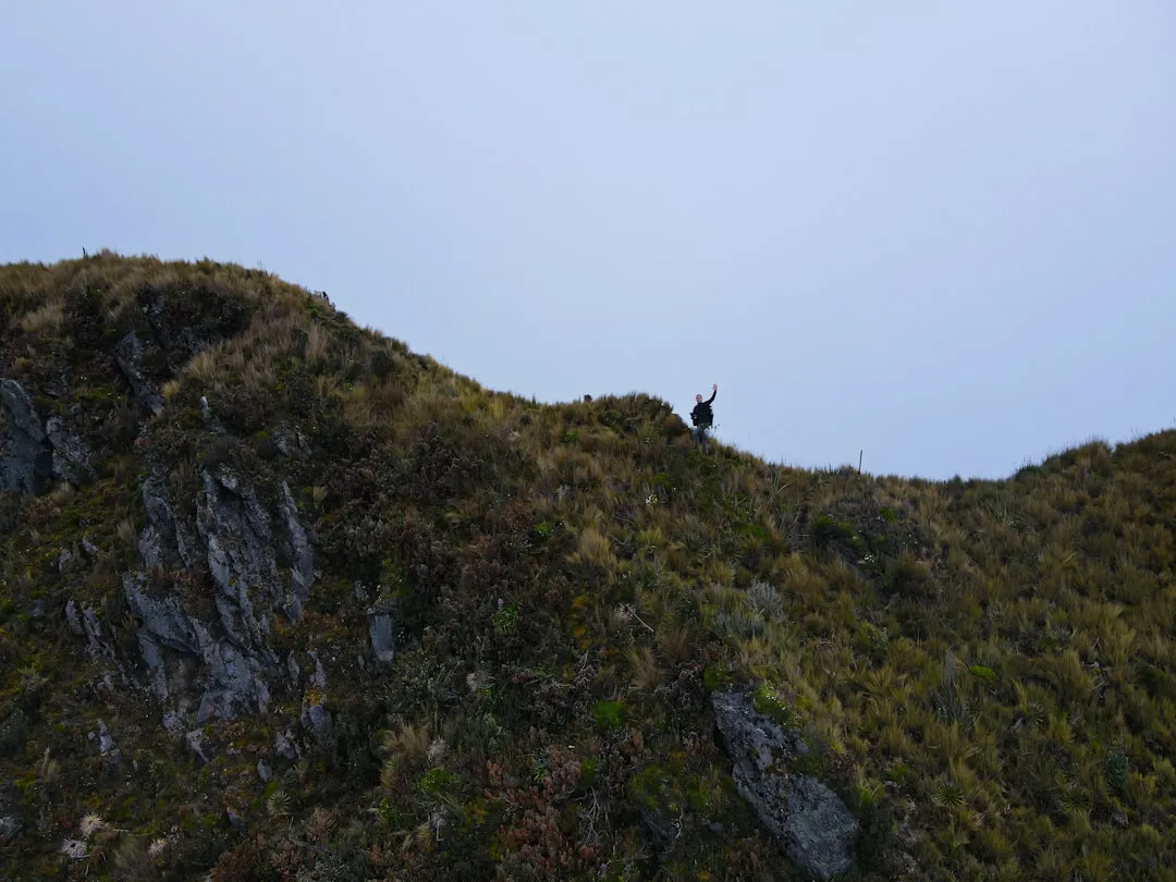 Person on a cliff edge with bright view, representing unlock your potential