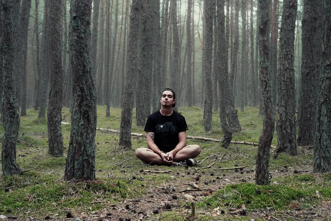 Person meditating outdoors highlighting mindfulness for self-compassion in daily life